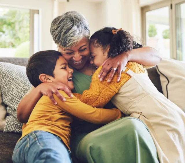 Young young kids hugging their grandmother
